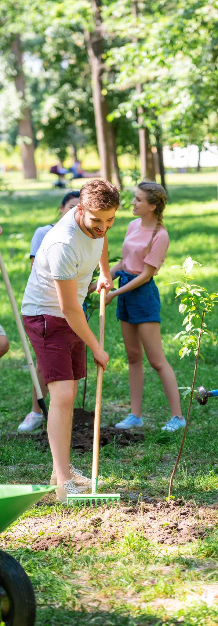 men and women planting new trees and volunteering in park, Local Missions at Engedi Church.