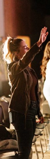 Woman lifting her hands in praise and worship at Engedi Español, a Spanish-speaking church in Holland, Michigan.