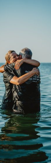 People hugging after baptism in Lake Michigan. Get baptized at Engedi Church in West Michigan.